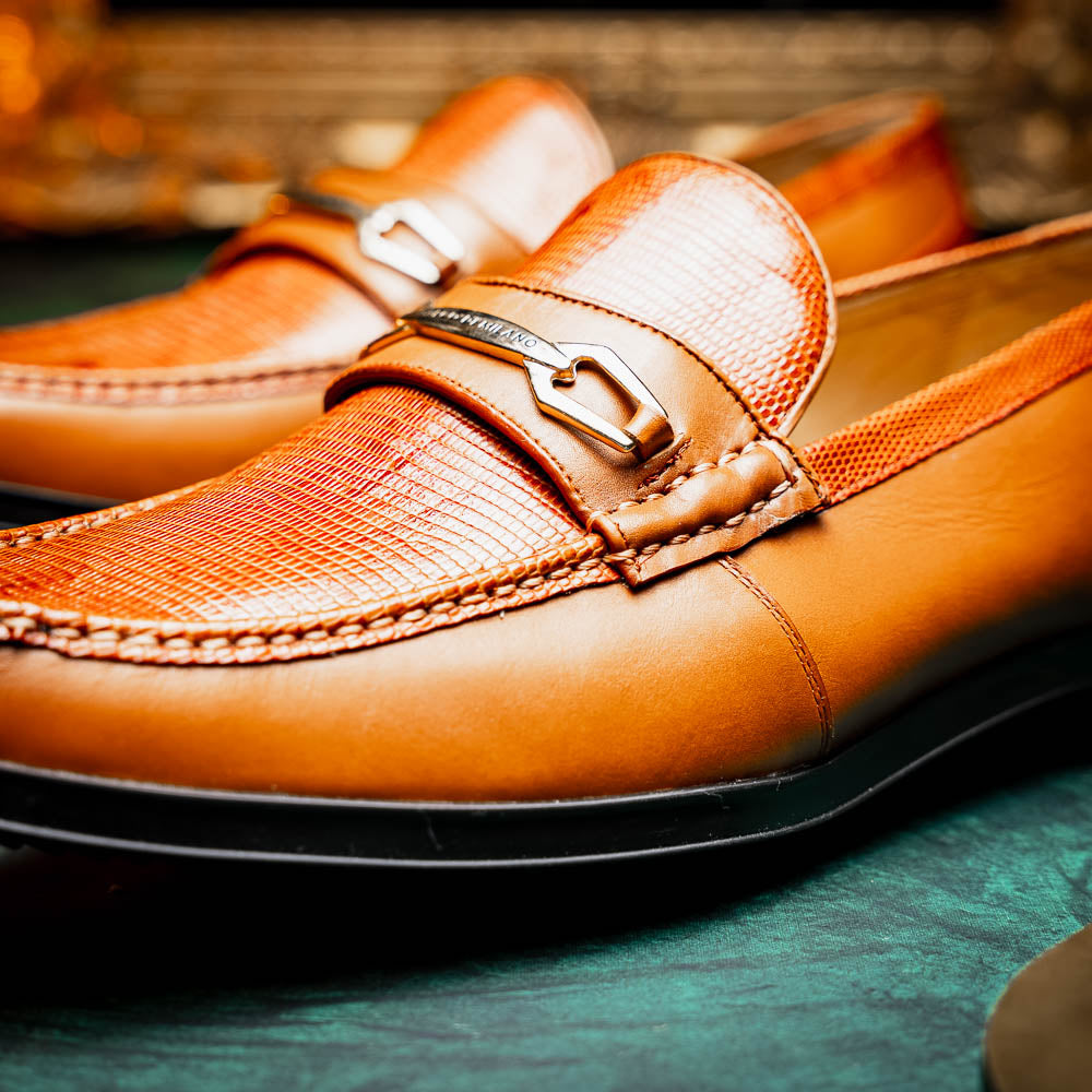 The Marco Di Milano Ravello Honey is a brown leather loafer with a textured finish and metal detail, displayed upright and on its side to show the rubber sole—ideal for those seeking luxury footwear.