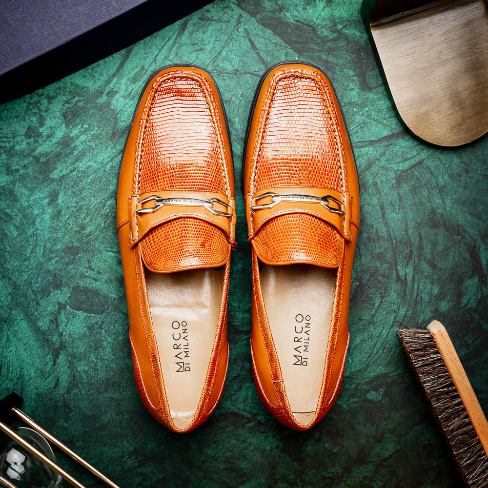The Marco Di Milano Ravello Honey is a brown leather loafer with a textured finish and metal detail, displayed upright and on its side to show the rubber sole—ideal for those seeking luxury footwear.
