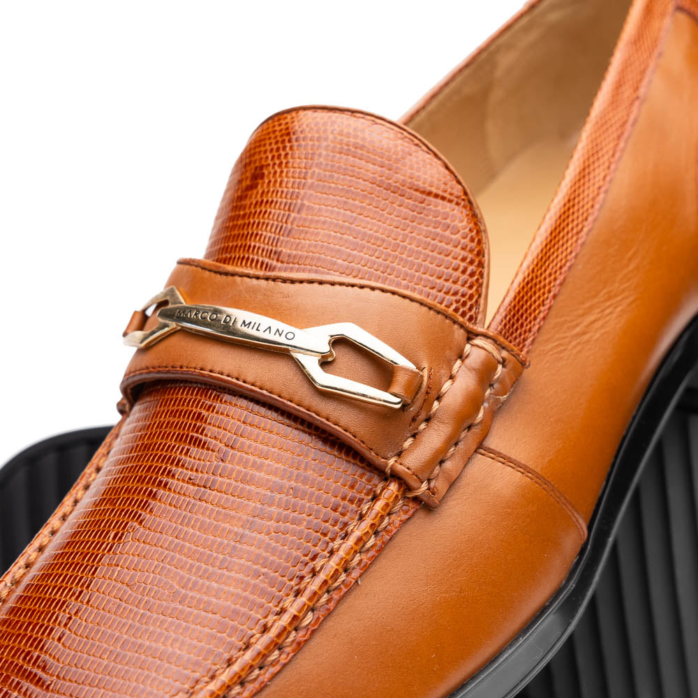 The Marco Di Milano Ravello Honey is a brown leather loafer with a textured finish and metal detail, displayed upright and on its side to show the rubber sole—ideal for those seeking luxury footwear.