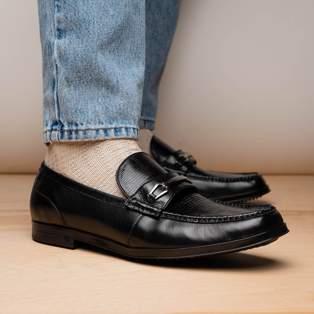 The Ravello Black by Marco Di Milano is a pair of black leather loafers with metal accents, textured uppers, a red interior lining, and ribbed rubber soles—making an exquisite statement in luxury footwear.