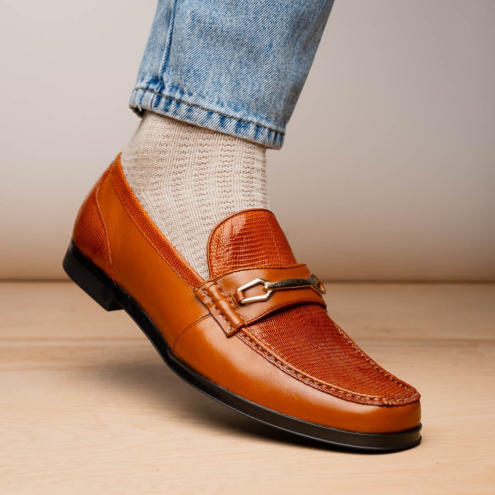 The Marco Di Milano Ravello Honey is a brown leather loafer with a textured finish and metal detail, displayed upright and on its side to show the rubber sole—ideal for those seeking luxury footwear.