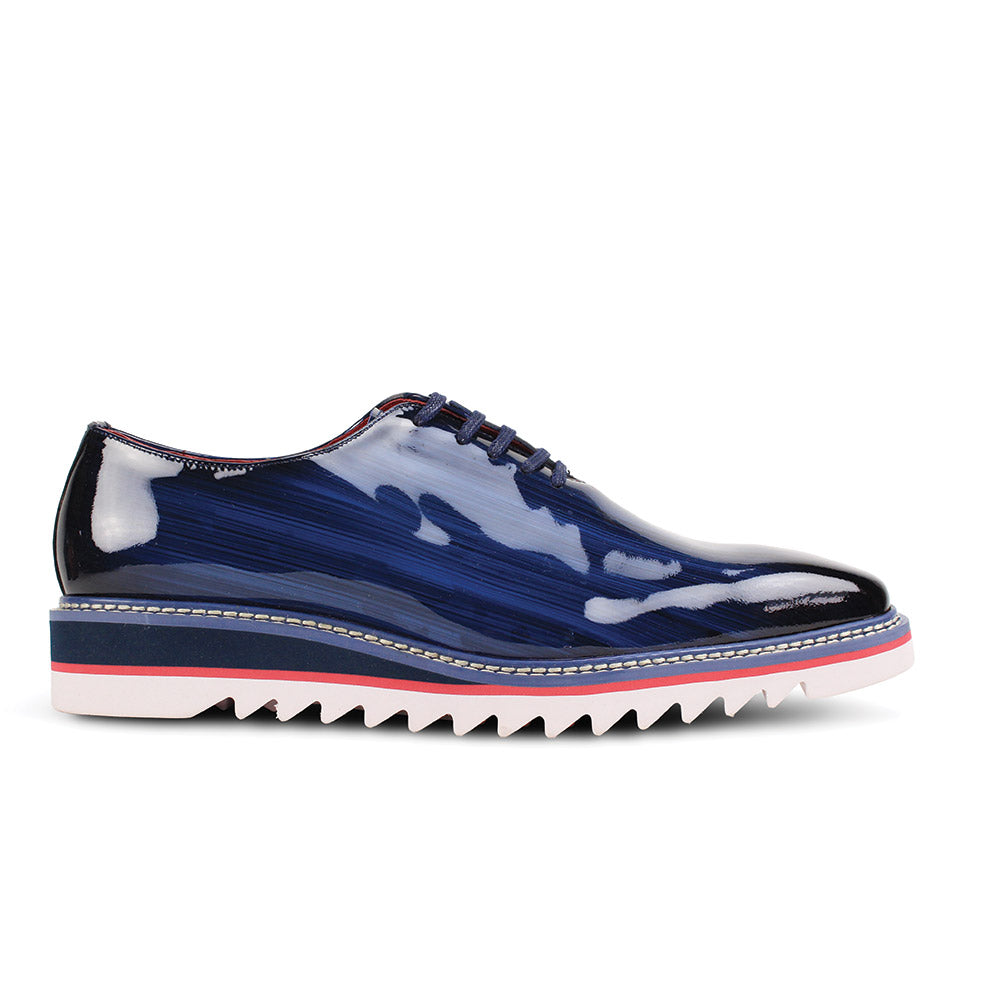 The GIOVANNI Giovanni Ruben Cobalt Patent Leather Shoes feature a glossy blue finish, red lining, blue laces, a lightweight white sole with pink and black trim, plain toe design, and genuine leather construction.