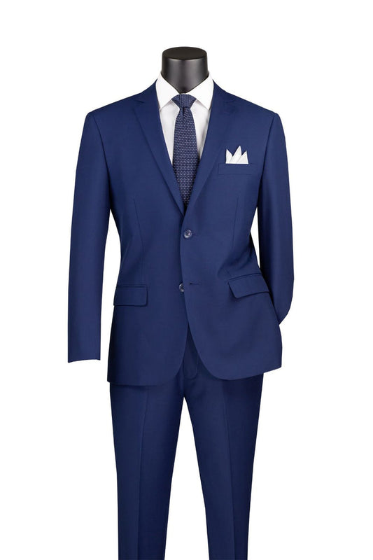 The Vinci Suits Slim Fit 2 Piece 2 Button Suit (Patriot Blue) SC900-12 features a notch lapel and is made from a wrinkle-resistant poly/rayon blend. It's displayed on a mannequin with a white dress shirt, coordinating blue tie, and crisp white pocket square.