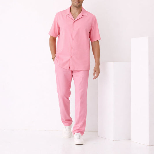 A man stands in a minimal white room wearing the Inserch Crepe Camp Collar Shirt SE9356-00057 in Summer Pink, paired with matching pants and white sneakers.