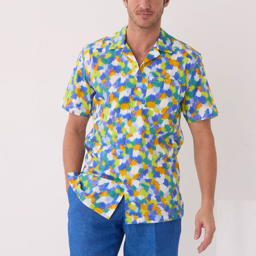 A man wears the Inserch SS Dot Print Shirt SS015-00066 Multi, a premium cotton short-sleeve button-up with a colorful dot motif, paired with blue pants, standing against a plain light background.