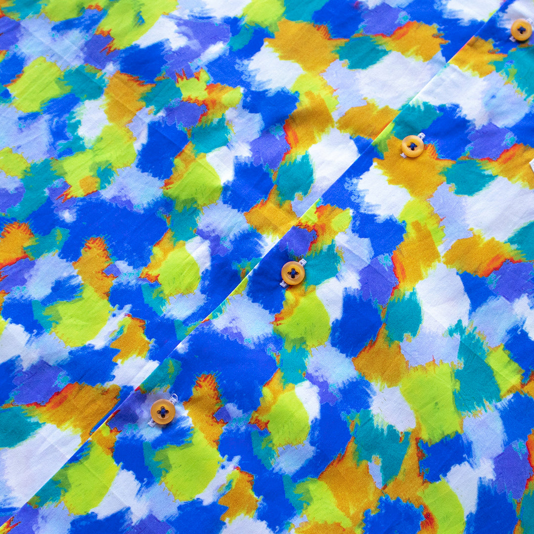 A man wears the Inserch SS Dot Print Shirt SS015-00066 Multi, a premium cotton short-sleeve button-up with a colorful dot motif, paired with blue pants, standing against a plain light background.