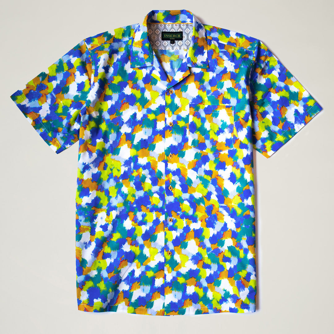 A man wears the Inserch SS Dot Print Shirt SS015-00066 Multi, a premium cotton short-sleeve button-up with a colorful dot motif, paired with blue pants, standing against a plain light background.