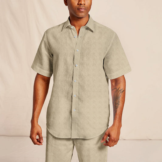 A man wearing an Inserch short-sleeve, button-up linen shirt (SS717-00006 in Oatmeal) with matching pants and a tattoo on his right arm.