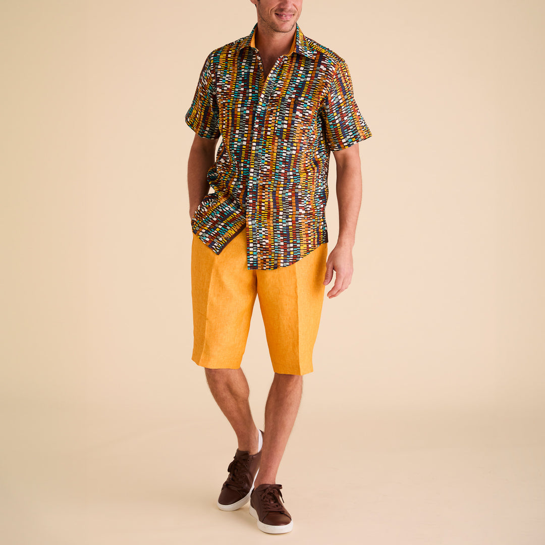 The Inserch SS Geo Print Linen Shirt (SS7918-00167 Cacao) is a short-sleeve, collared shirt made from premium European flax, showcasing a multicolored geometric print in yellow, brown, blue, and white on beige.