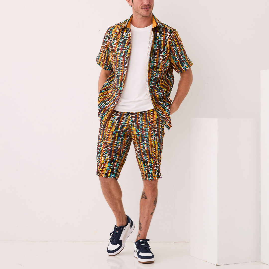 The Inserch SS Geo Print Linen Shirt (SS7918-00167 Cacao) is a short-sleeve, collared shirt made from premium European flax, showcasing a multicolored geometric print in yellow, brown, blue, and white on beige.