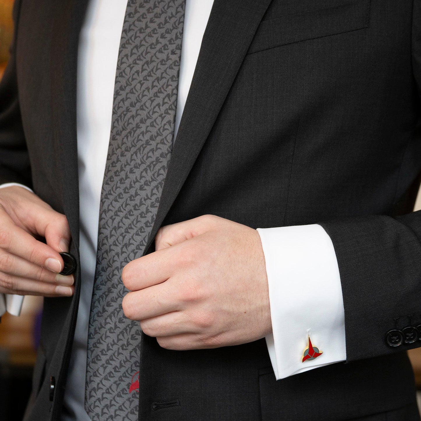 The Cufflinks.com Star Trek Klingon Gray Men's Tie showcases a repeating black symbol pattern and a bold red Klingon emblem at the tip—perfect for any Star Trek collection.