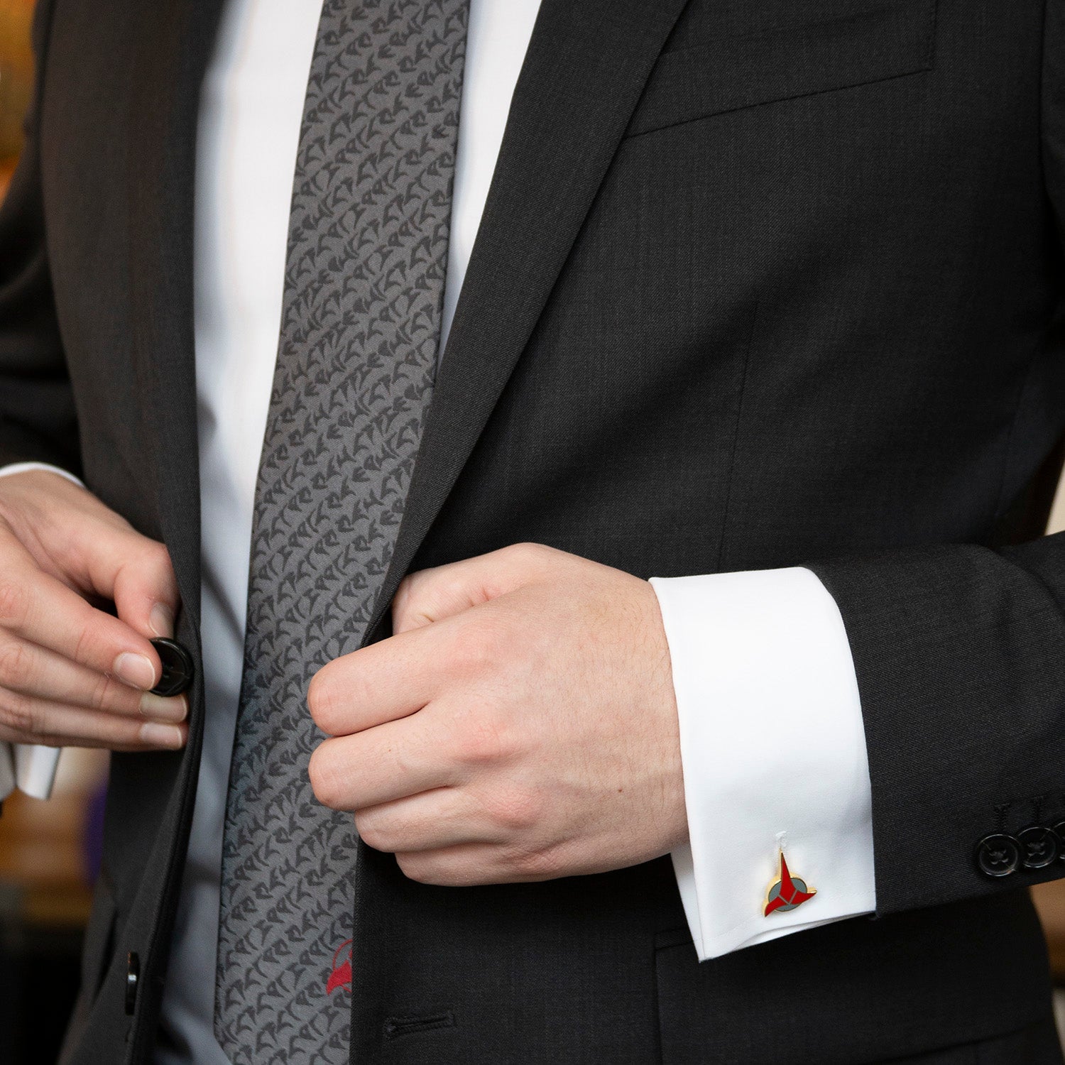 The Cufflinks.com Star Trek Klingon Gray Men's Tie showcases a repeating black symbol pattern and a bold red Klingon emblem at the tip—perfect for any Star Trek collection.