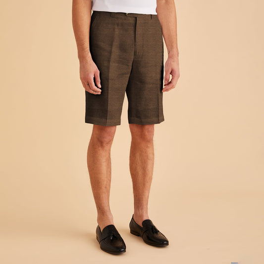 Someone wearing a white shirt, Inserch Modern Linen Shorts ST31-00064 Mocha, and black loafers stands against a beige background.