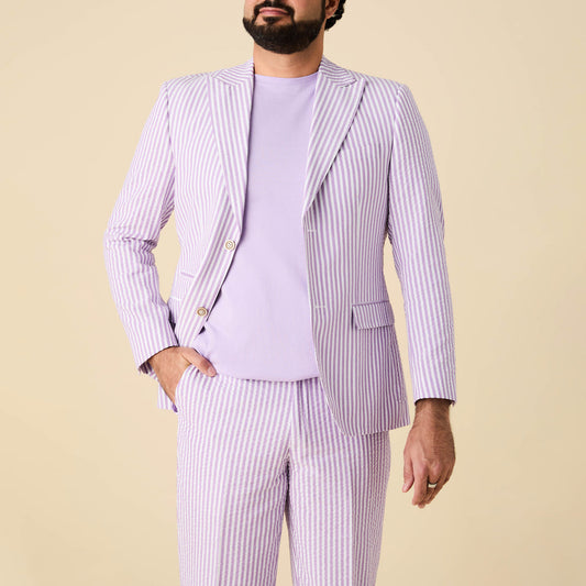 A person wearing the Inserch Seersucker Stripe Blazer SU660155-00119 Lavender by Inserch stands against a beige background, paired with matching seersucker pants and a lavender t-shirt.