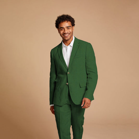 Dressed in an Inserch Slim Linen Suit SU880-00200 Emerald, paired with brown dress shoes, an individual exudes confidence against a beige background.
