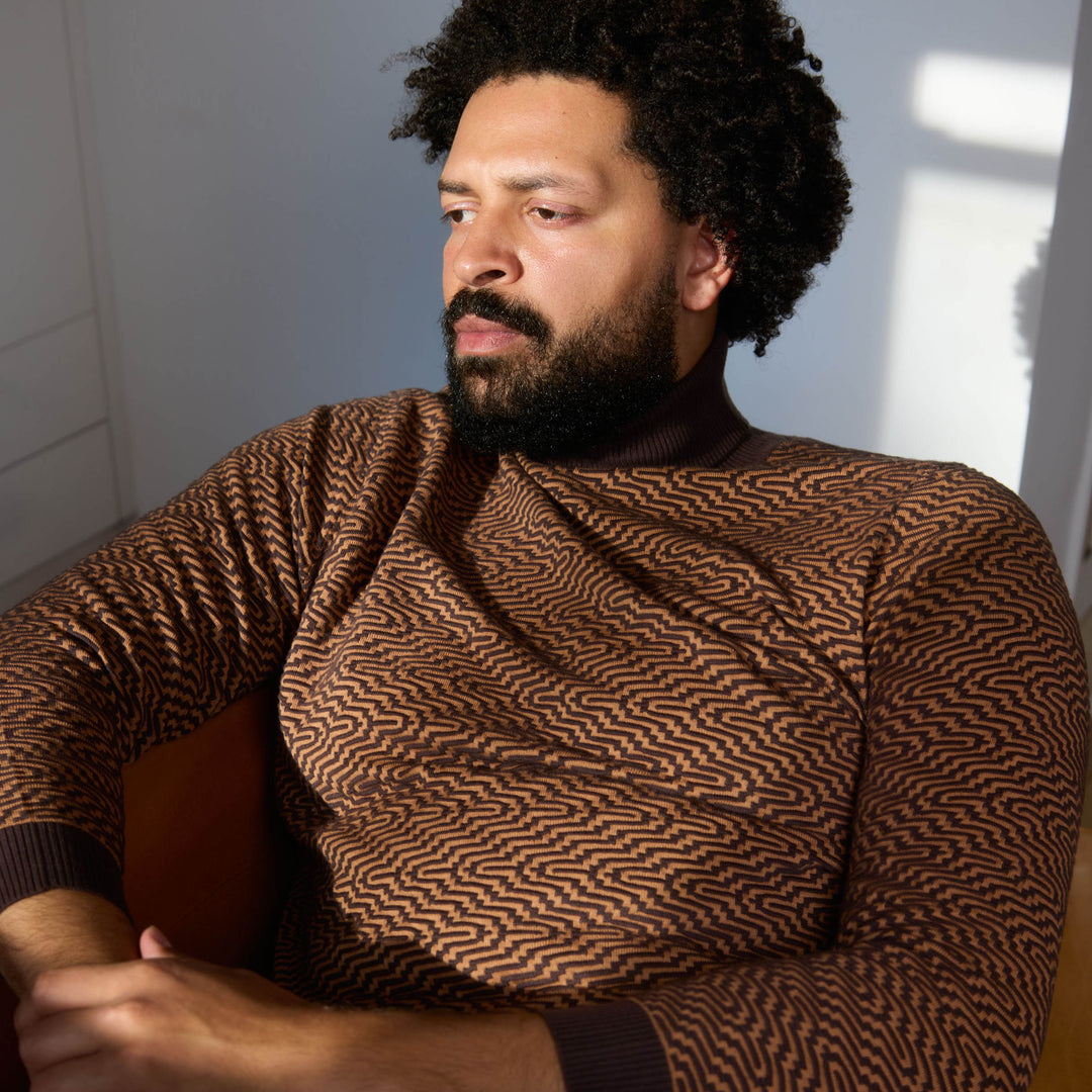 A man stands with his hands in his pockets against a neutral background, wearing the Inserch Intarsia Turtleneck Sweater SW304-00043 Espresso and dark brown pants.