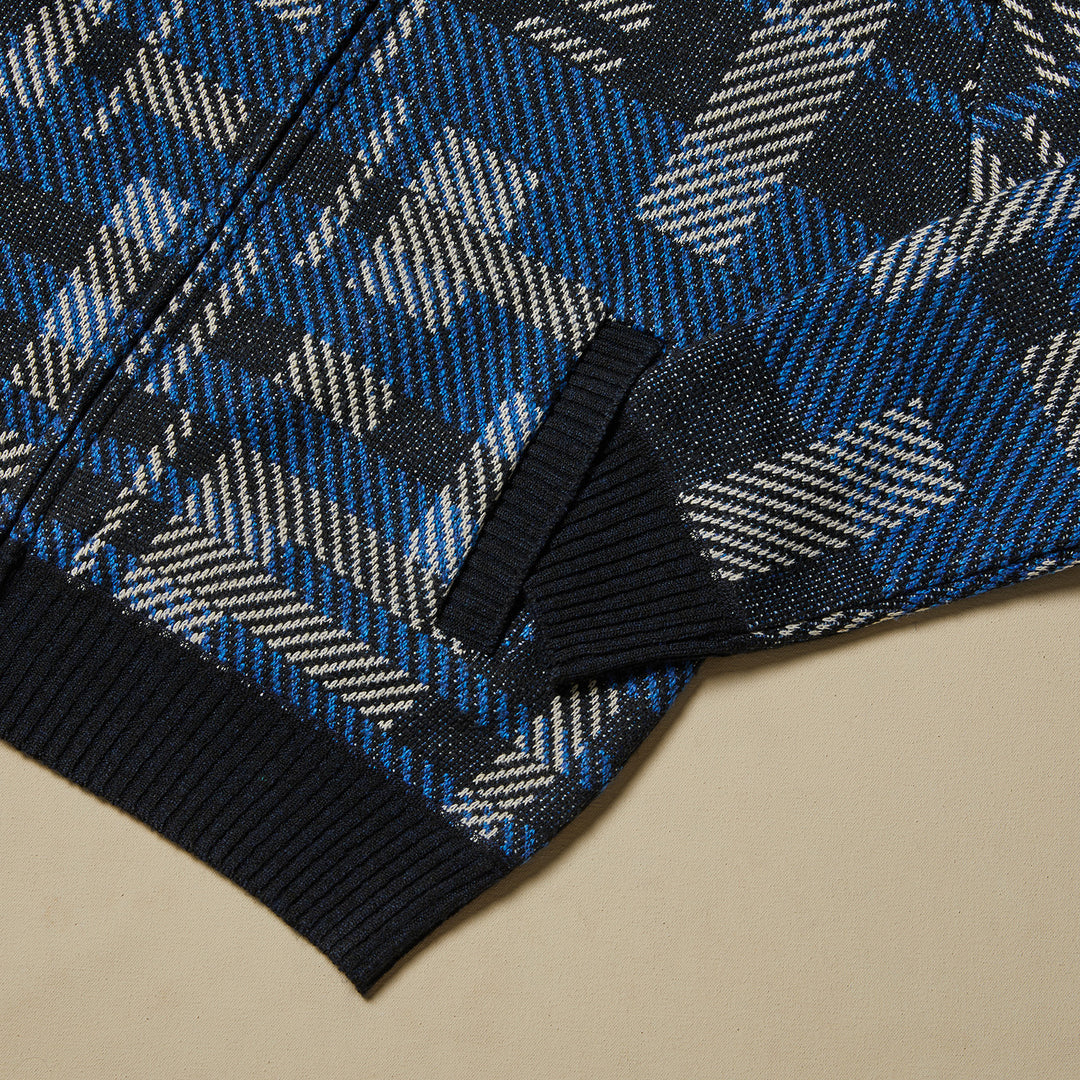 A man smiles against a beige background, wearing the Inserch Geometric Full Zip Baseball Knit Jacket SW609-11 Navy over a white shirt and gray jeans.