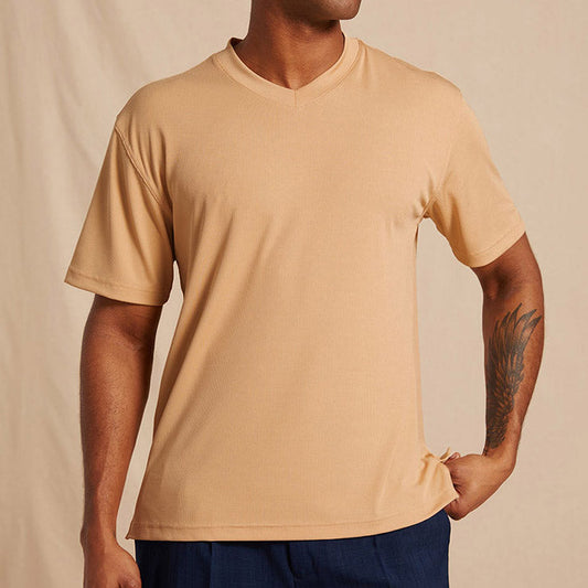 A man wears the Inserch Rib V Neck T-Shirt T300-00084 in tan by Inserch, made from a soft polyester-spandex blend, paired with dark blue pants against a plain light background.