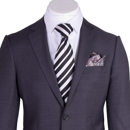 The Tiglio Luxe Novello Charcoal Gray Pure Wool Men’s Suit (TIG1010) by Tiglio Luxe, styled with a white shirt, striped tie, and patterned pocket square on a mannequin, highlights the sophistication of tailored menswear.