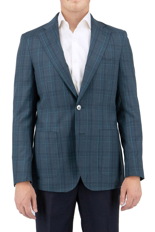 A man stylishly attired in a Tiglio Luxe Turquoise Green jacket with windowpane pattern over a classic white dress shirt and black pants, exuding timeless elegance and sartorial sophistication.