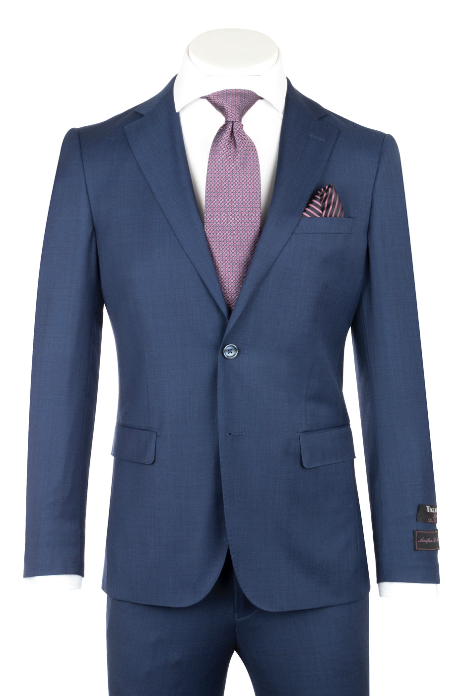 Displayed on a headless mannequin, the Porto Blue Sharkskin Slim Fit Pure Wool Suit by Tiglio Luxe (TS4066/2) is paired with a crisp white dress shirt, a purple patterned tie, and a matching pocket square—an exquisite example of luxury men’s tailoring that highlights the elegance and sophistication of Tiglio Luxe menswear.