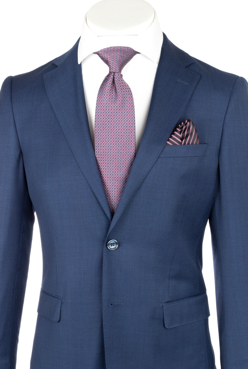 Displayed on a headless mannequin, the Porto Blue Sharkskin Slim Fit Pure Wool Suit by Tiglio Luxe (TS4066/2) is paired with a crisp white dress shirt, a purple patterned tie, and a matching pocket square—an exquisite example of luxury men’s tailoring that highlights the elegance and sophistication of Tiglio Luxe menswear.