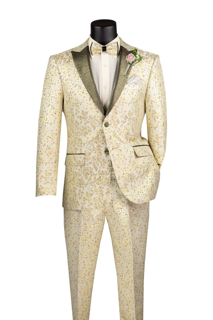 A mannequin displays the Vinci Suits Slim Fit 2 Pieces with Matching Bow Tie Tuxedo Champagne TSJQ-1, featuring an ornate cream suit with gold floral patterns and a pink boutonniere. The peak lapel adds elegance, and its wrinkle-resistant fabric keeps it pristine.