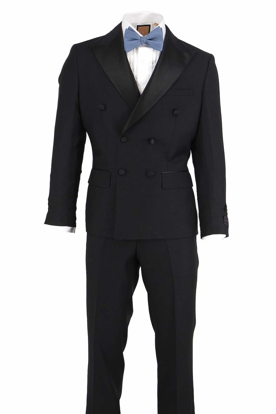 The Tiglio Luxe Santorini is a black, slim fit, double-breasted pure wool tuxedo (TIG1001) with satin peaked lapels, elegantly paired with a white dress shirt and light blue bow tie on display—a striking example of European fit men’s luxury by Tiglio Luxe.