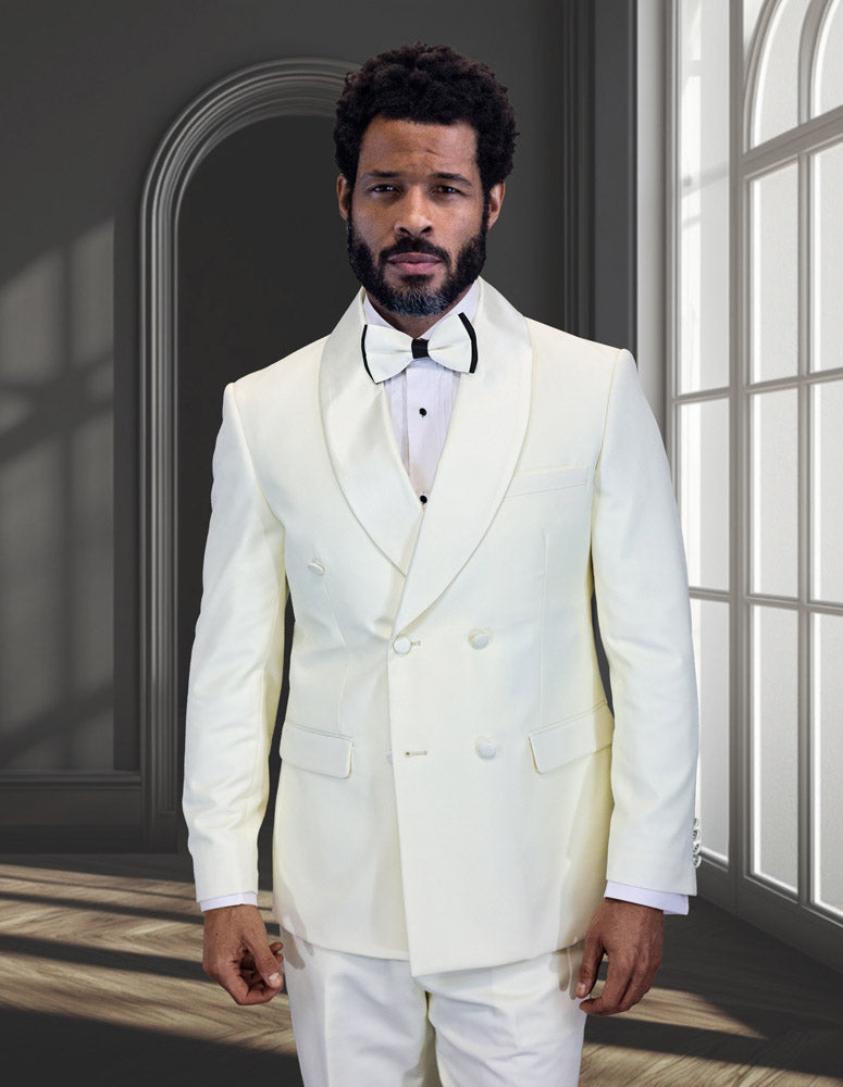 A man with a beard and short curly hair wears the STATEMENT CLOTHING | TUX-DBS-OFFWHITE by Statement Clothing, paired with a bow tie, standing in a bright room with arched windows and dark walls.