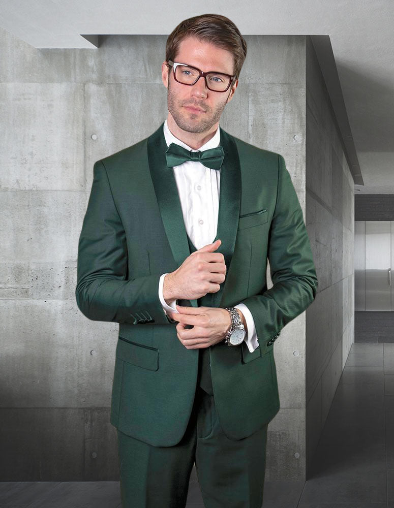 A man in the Statement Clothing STATEMENT CLOTHING | TUX-SH-HUNTER-HUNTER tuxedo with a white shirt, bow tie, and flat front pants stands in a stylish concrete-walled interior, gazing slightly to the side.