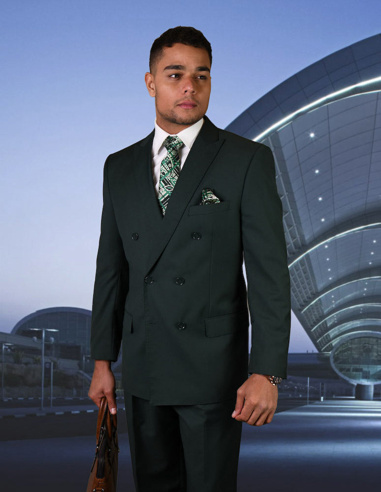 A man in the STATEMENT CLOTHING | TZD-100-HUNTER Italian wool suit by Statement Clothing, paired with a patterned tie and briefcase, stands outside a modern curved building at dusk.