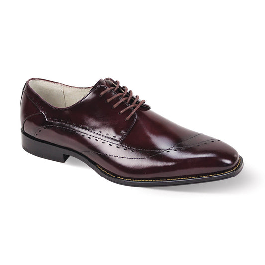 The Giovanni Triston by GIOVANNI is a burgundy leather dress shoe with an asymmetrical design, detailed lace-up closure, and intricate decorative stitching.