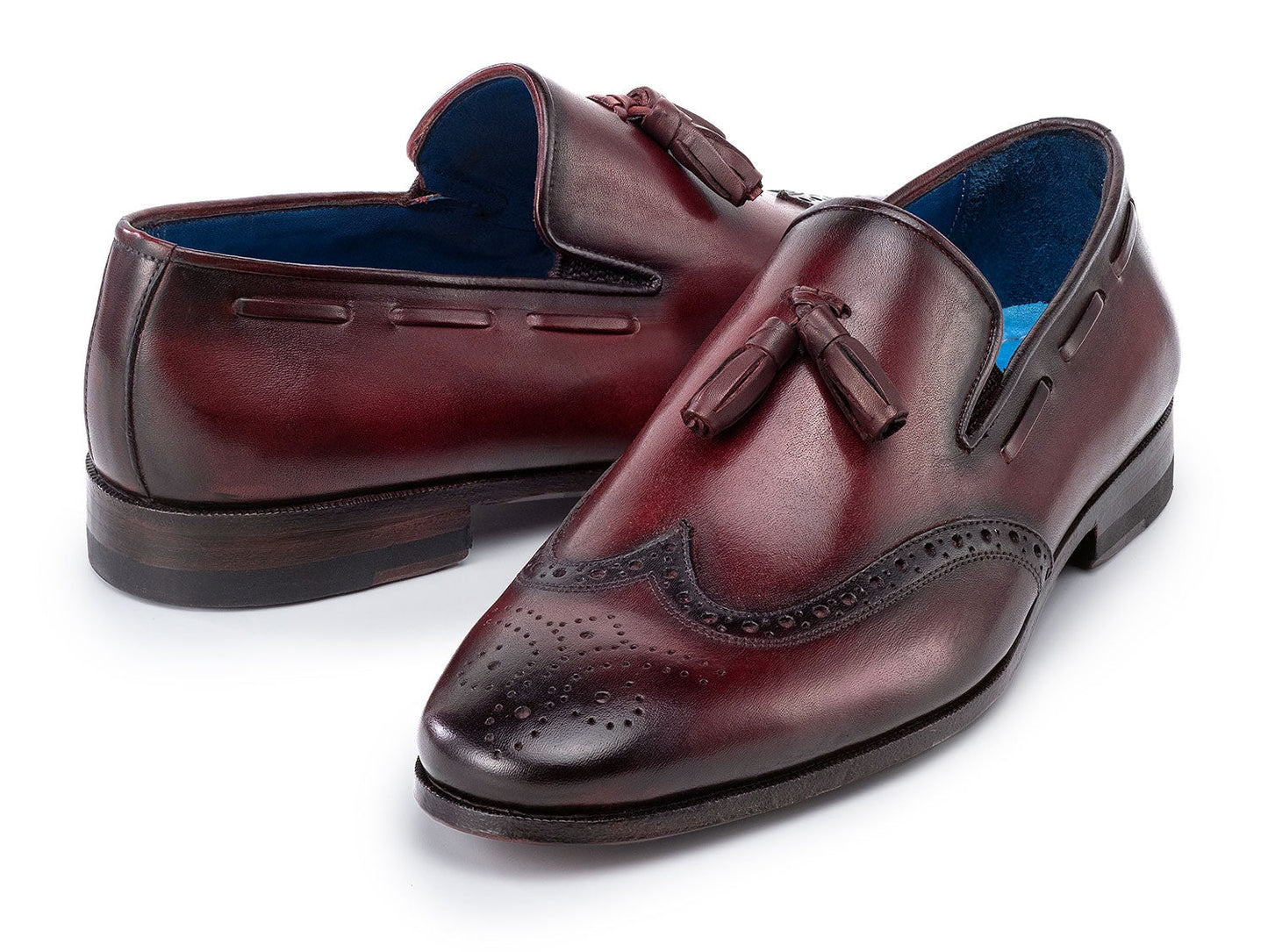 The Paul Parkman Wingtip Tassel Loafers Bordeaux (WL34-BRD) are men's hand-painted calfskin loafers in burgundy, featuring perforated detailing, blue inner lining, and displayed on a white background.