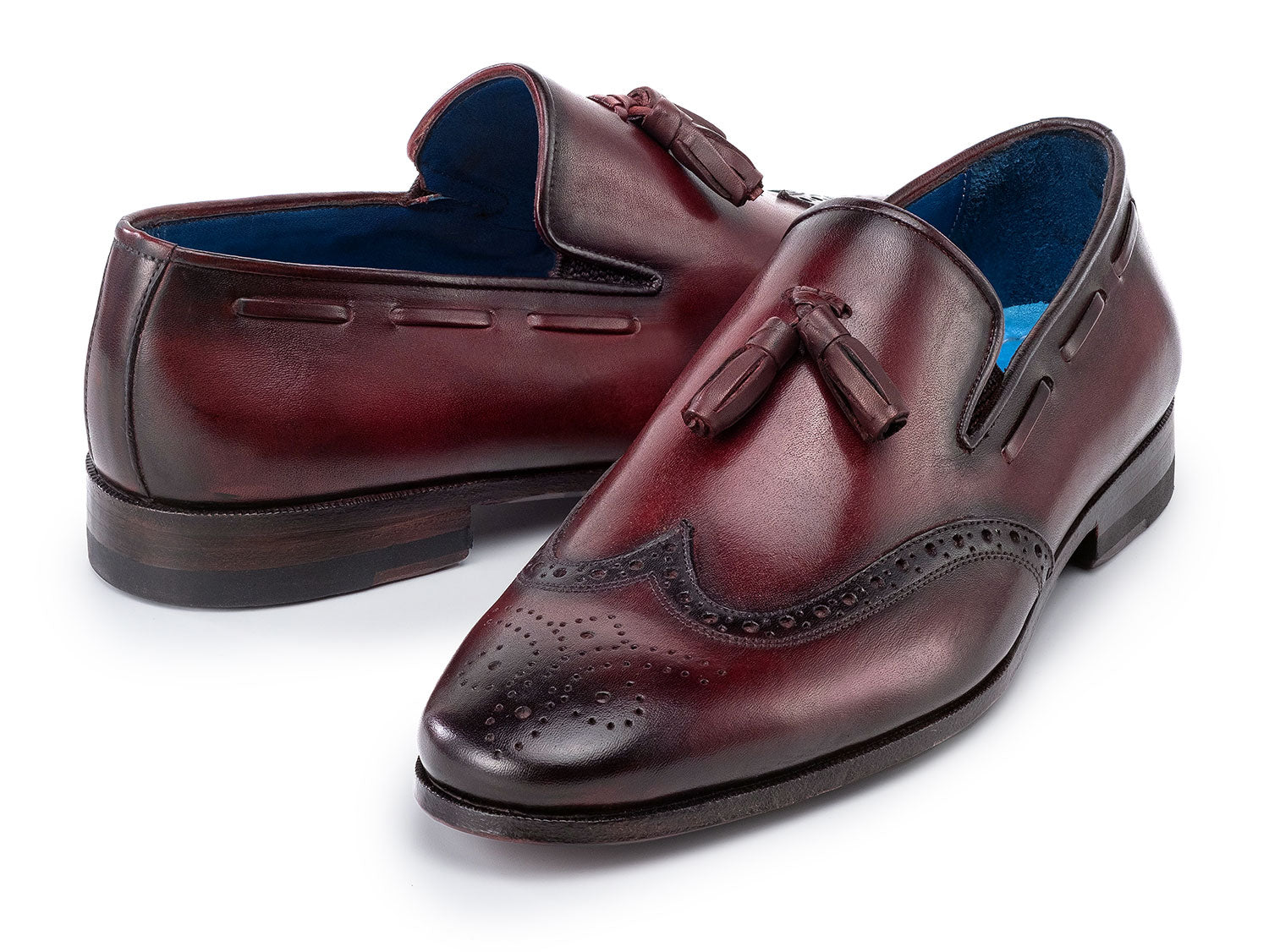 The Paul Parkman Wingtip Tassel Loafers Bordeaux (WL34-BRD) are men's hand-painted calfskin loafers in burgundy, featuring perforated detailing, blue inner lining, and displayed on a white background.