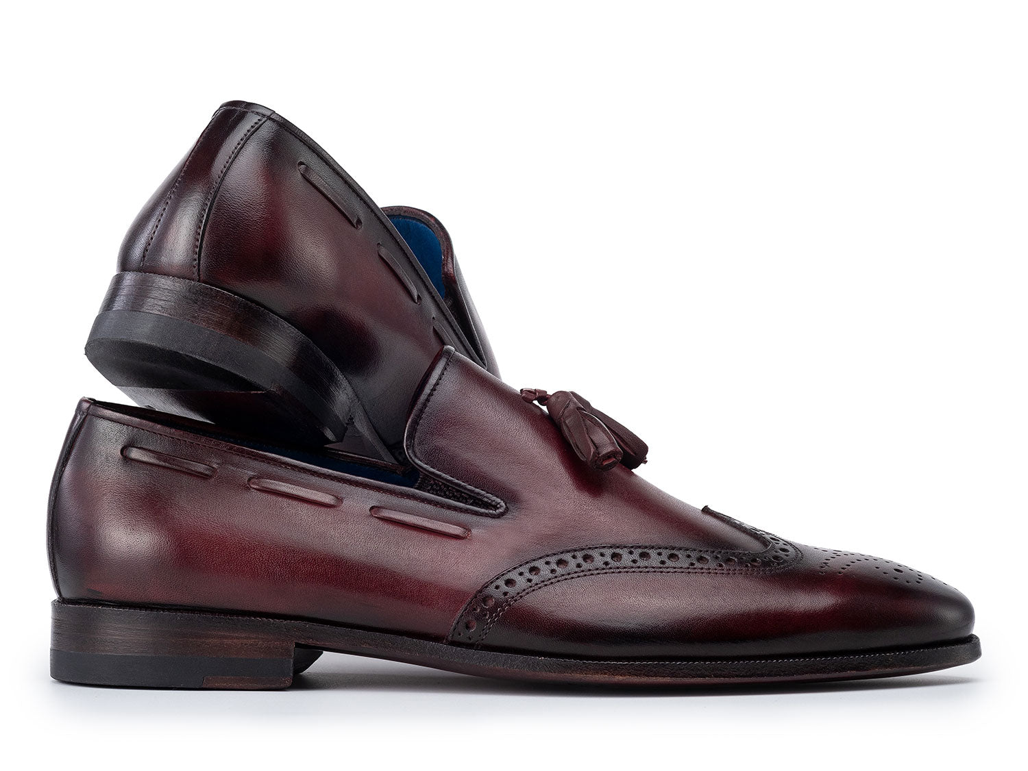 The Paul Parkman Wingtip Tassel Loafers Bordeaux (WL34-BRD) are men's hand-painted calfskin loafers in burgundy, featuring perforated detailing, blue inner lining, and displayed on a white background.