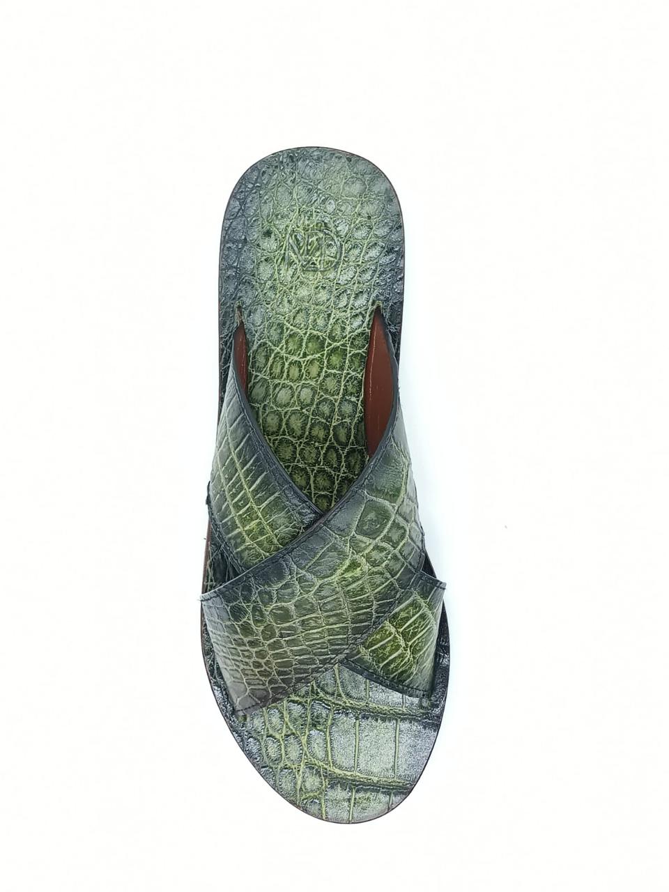 The Elios Green by Marco Di Milano is a luxurious sandal featuring green crocodile-patterned leather, crisscross straps, a flat sole, and hand-painted finishes, beautifully displayed on a white background.