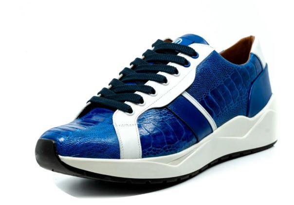 The Marco Di Milano Lyon Blue / White sneakers feature blue and white tones, black laces, textured side panels, and sleek black outsoles, with one shoe displayed stylishly on its side against the other.