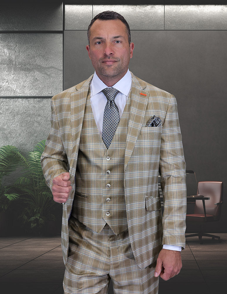 A man stands in a modern office with dark walls and green plants, wearing the STATEMENT CLOTHING | ZILO-1-TAN modern fit wool suit by Statement Clothing and a patterned tie.