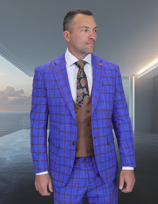 A man stands indoors with an ocean-view backdrop, dressed in the Statement Clothing ZILO-2-SAPPHIRE blue checkered suit, brown vest, white shirt, and patterned tie.