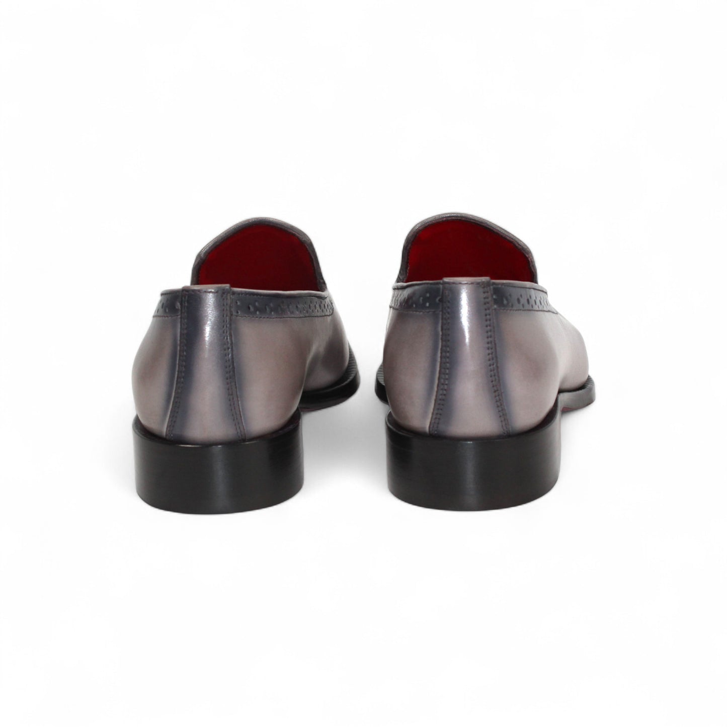 The Emilio Franco A014 Gray men's loafer features genuine grey leather, black toe and heel caps, subtle brogue details, red lining, and a low black heel—capturing minimalist style in a striking side profile.