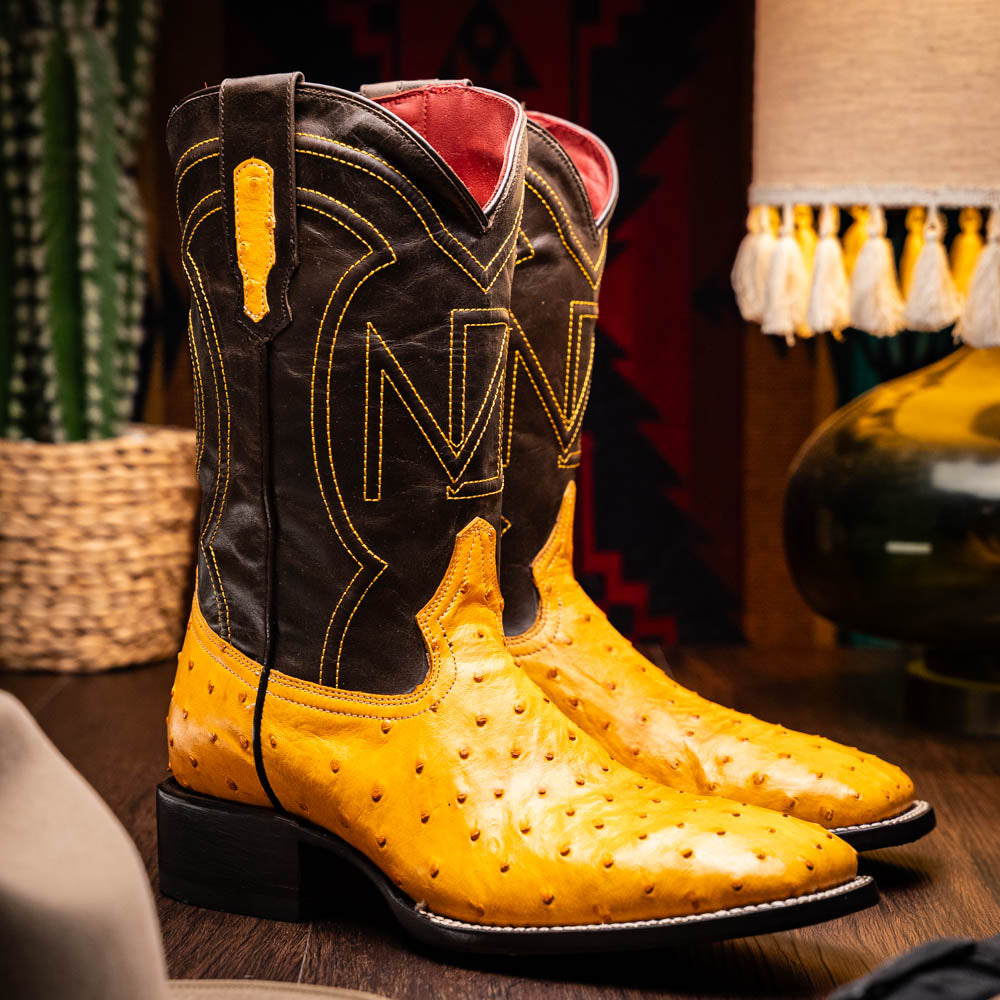 Introducing the Alabama Buttercup by Marco Di Milano: handcrafted cowboy boots with yellow genuine ostrich skin on the foot, dark brown leather shafts, and signature branding embossed on the sole.