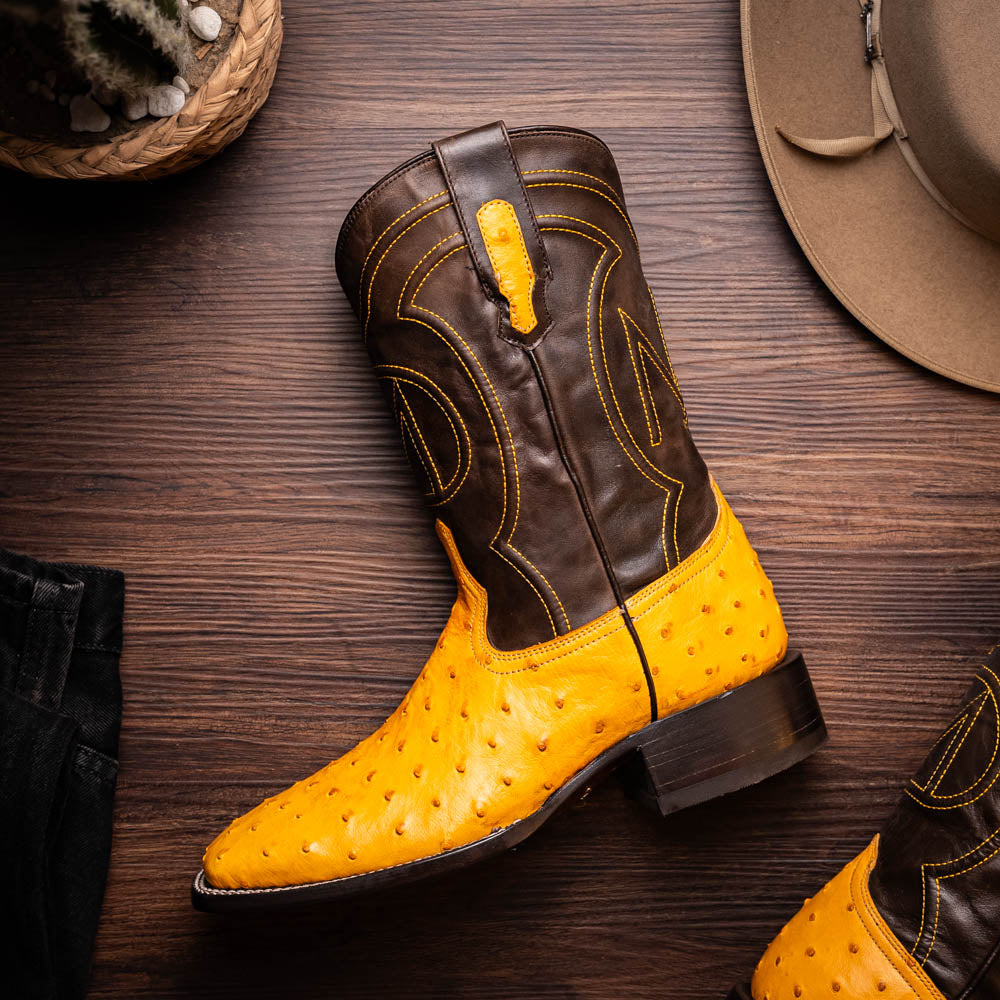 Introducing the Alabama Buttercup by Marco Di Milano: handcrafted cowboy boots with yellow genuine ostrich skin on the foot, dark brown leather shafts, and signature branding embossed on the sole.