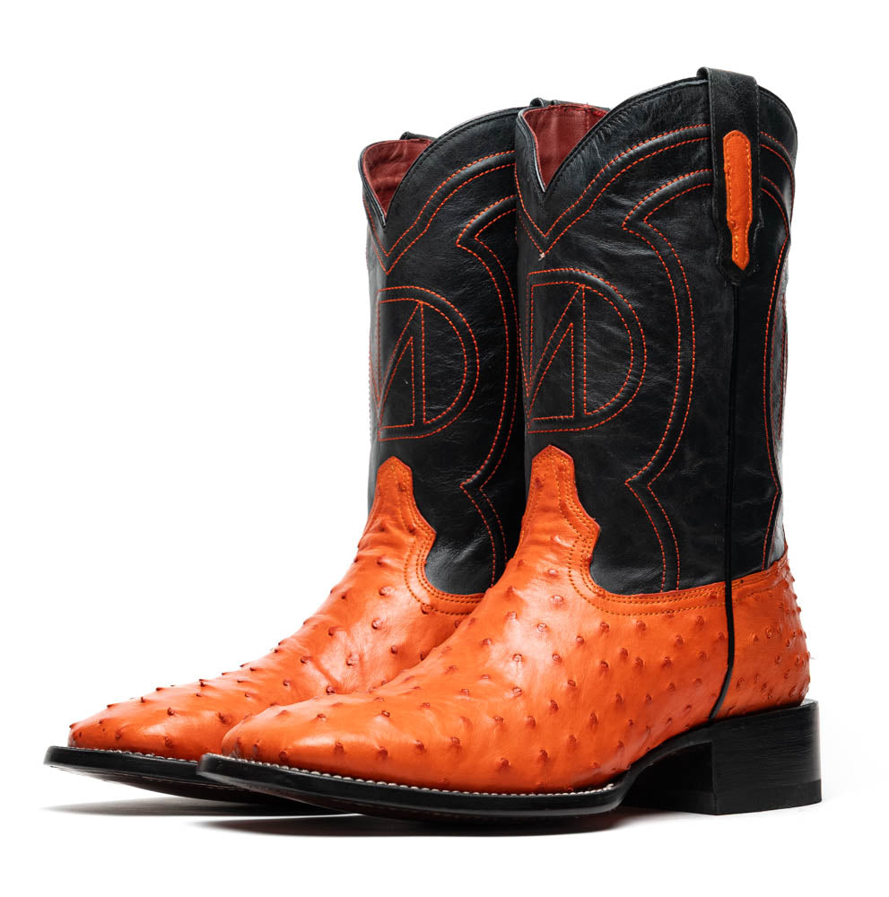 A pair of Alabama Orange cowboy boots by Marco Di Milano featuring a textured orange and black genuine ostrich upper and a visible logo on the leather sole.