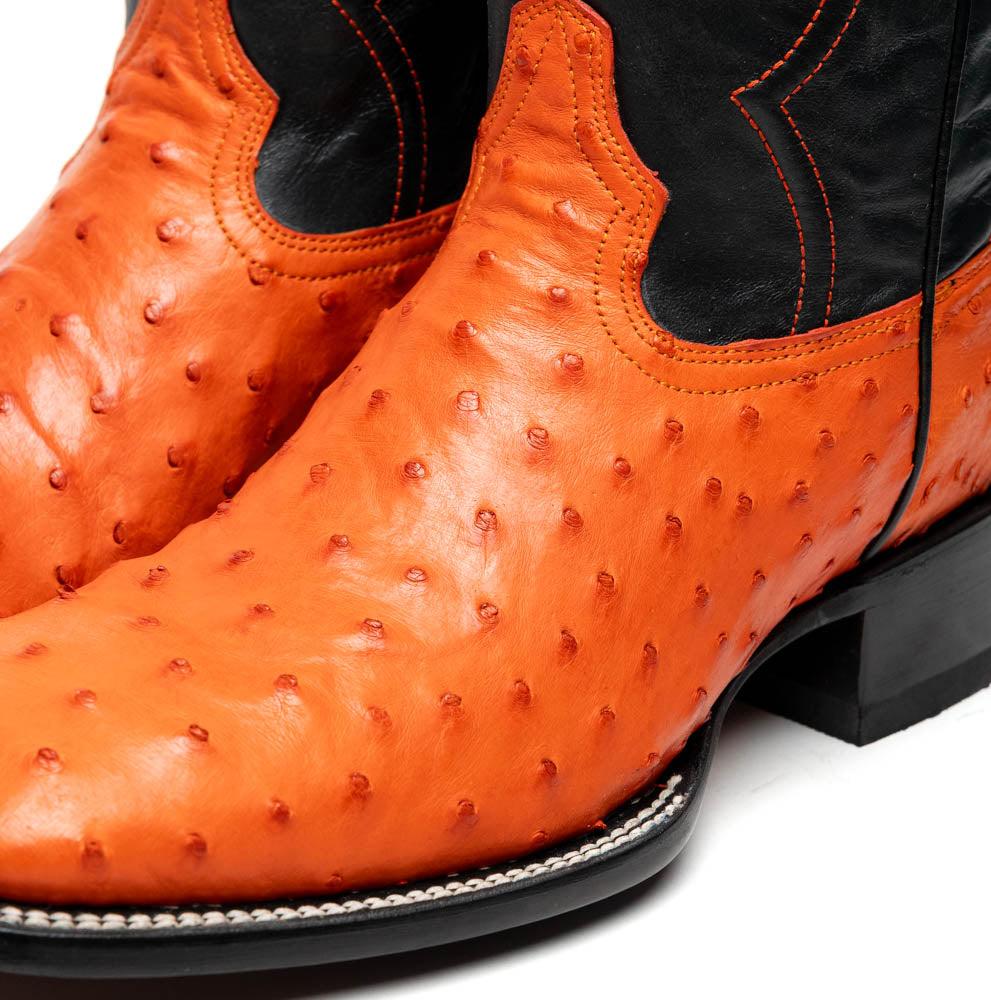 A pair of Alabama Orange cowboy boots by Marco Di Milano featuring a textured orange and black genuine ostrich upper and a visible logo on the leather sole.