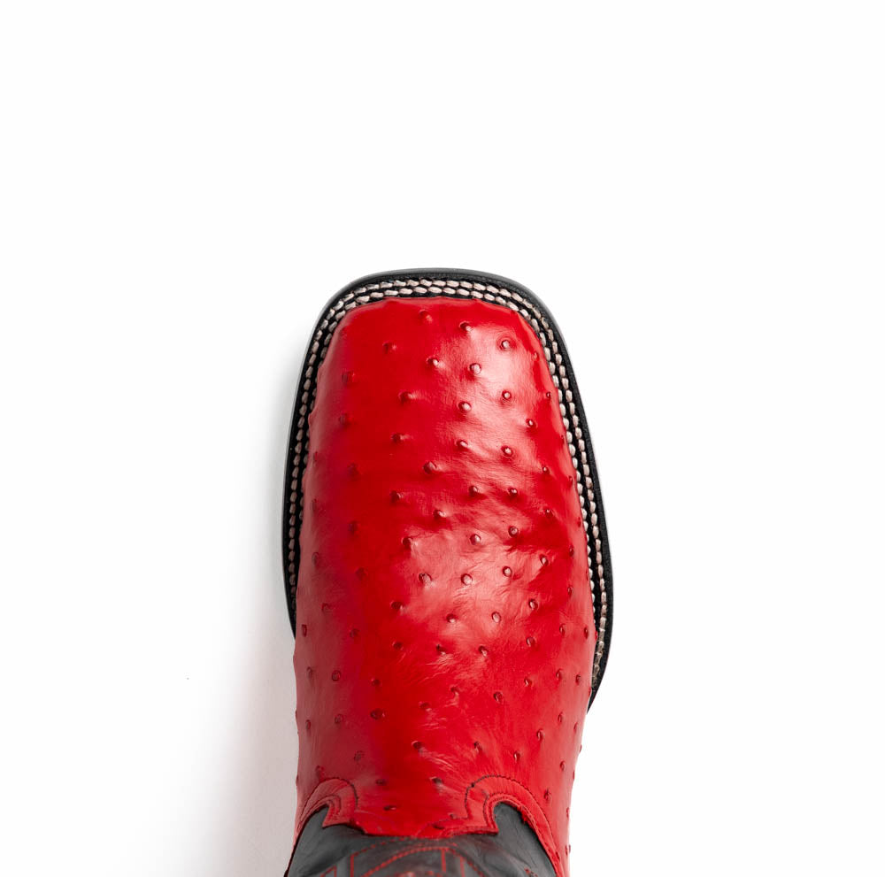 The Marco Di Milano Alabama Red boots feature handcrafted red and black textured leather; one stands upright while the other reveals the branded sole—a modern take on classic Western style.
