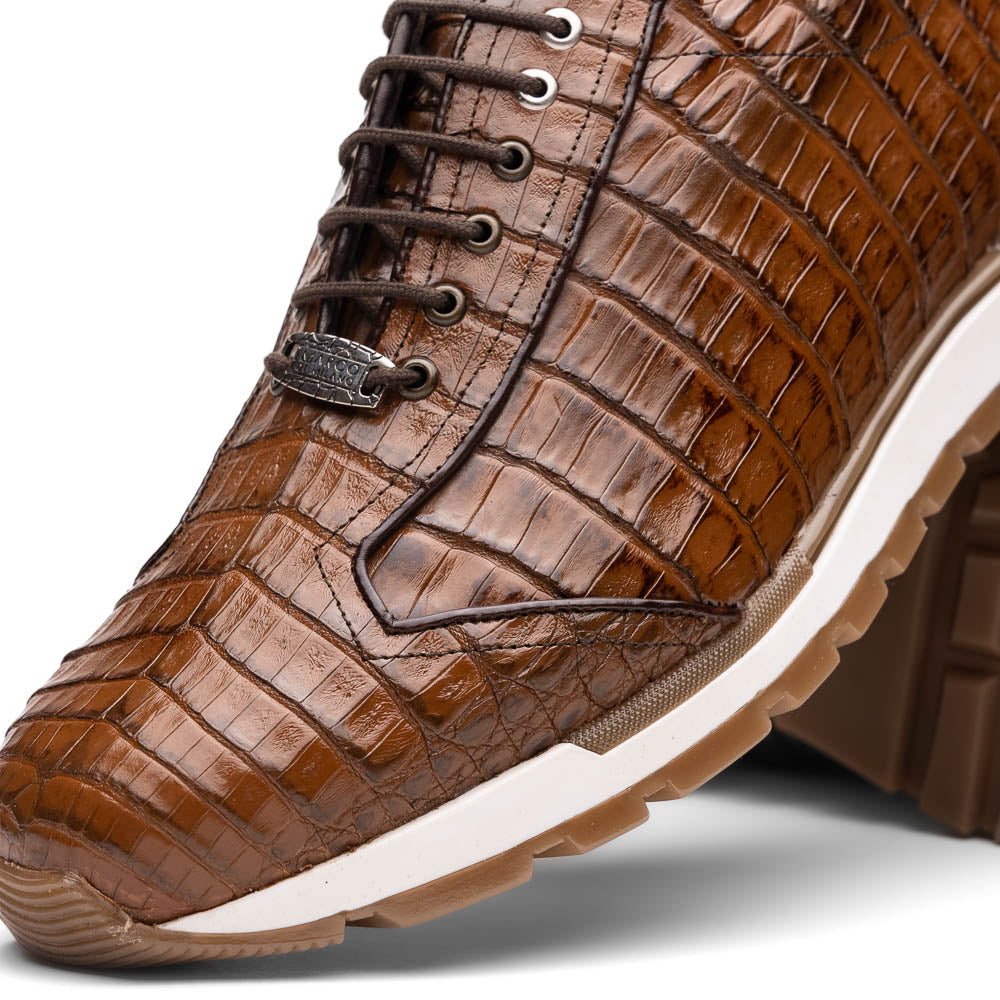 The Marco Di Milano Alonzo Bay Apache sneakers feature brown genuine caiman crocodile leather, white midsoles, brown rubber outsoles, a lace-up design, and a textured pattern—luxury footwear ideal for any occasion.