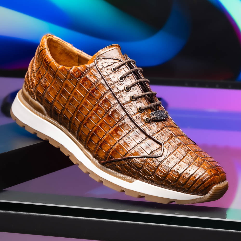 The Marco Di Milano Alonzo Bay Apache sneakers feature brown genuine caiman crocodile leather, white midsoles, brown rubber outsoles, a lace-up design, and a textured pattern—luxury footwear ideal for any occasion.