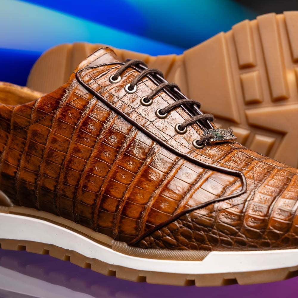 The Marco Di Milano Alonzo Bay Apache sneakers feature brown genuine caiman crocodile leather, white midsoles, brown rubber outsoles, a lace-up design, and a textured pattern—luxury footwear ideal for any occasion.