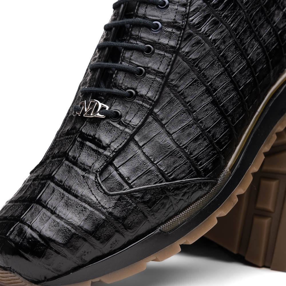 The Alonzo Black by Marco Di Milano: luxury men's sneakers crafted from black genuine caiman crocodile leather with a hand-painted finish and brown rubber soles—one shoe upright, the other leaning against it.