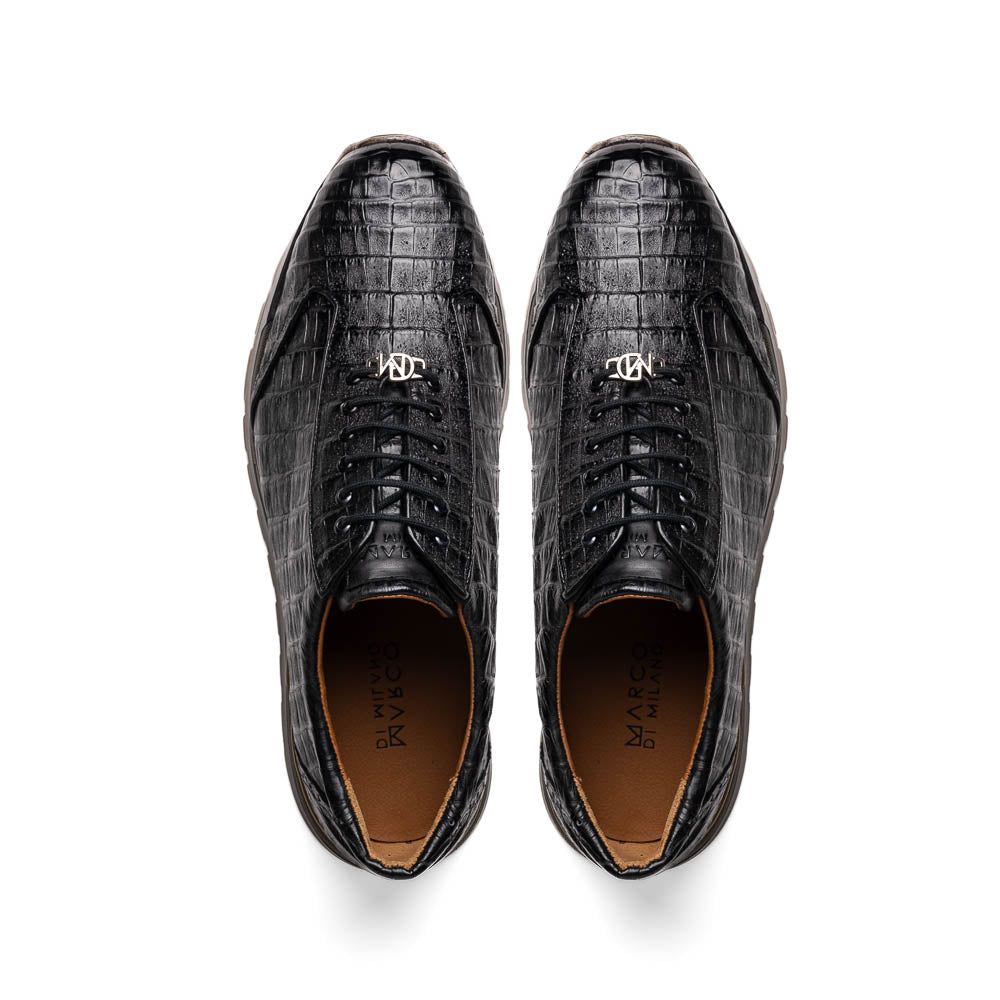 The Alonzo Black by Marco Di Milano: luxury men's sneakers crafted from black genuine caiman crocodile leather with a hand-painted finish and brown rubber soles—one shoe upright, the other leaning against it.